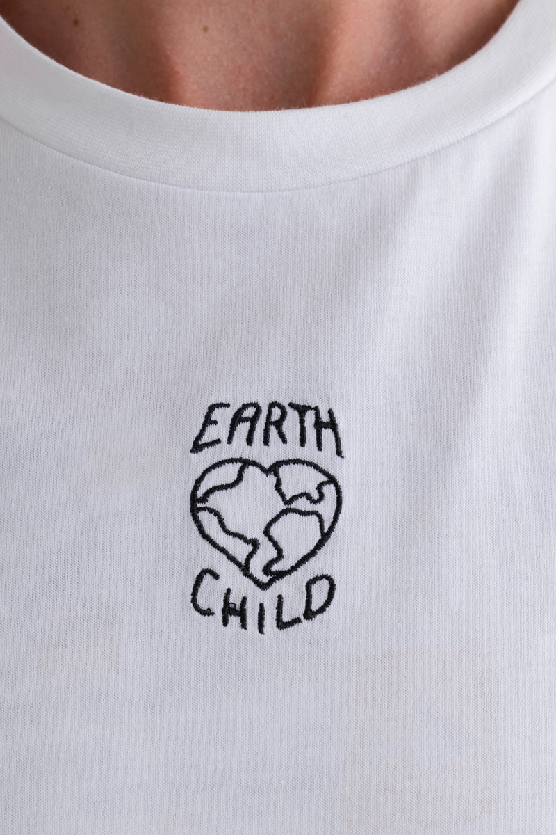 Hey Honey white t-shirt with "EARTH CHILD" embroidered in black, featuring a heart-shaped globe.