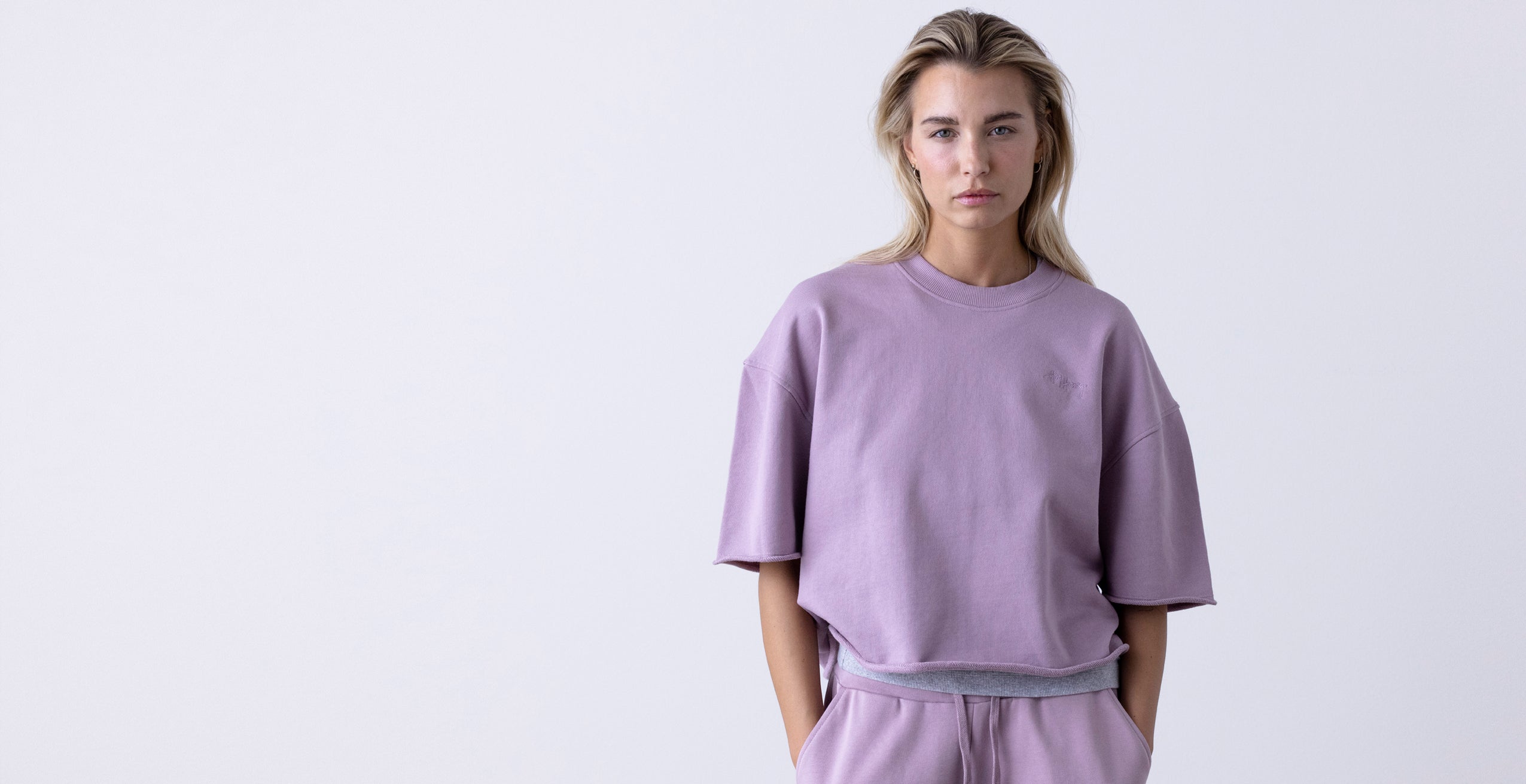 Blonde woman in a Hey Honey lilac oversized sweatshirt and matching sweatpants.